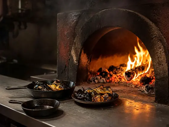 Concept image of cast iron pans beside a wood-fired oven