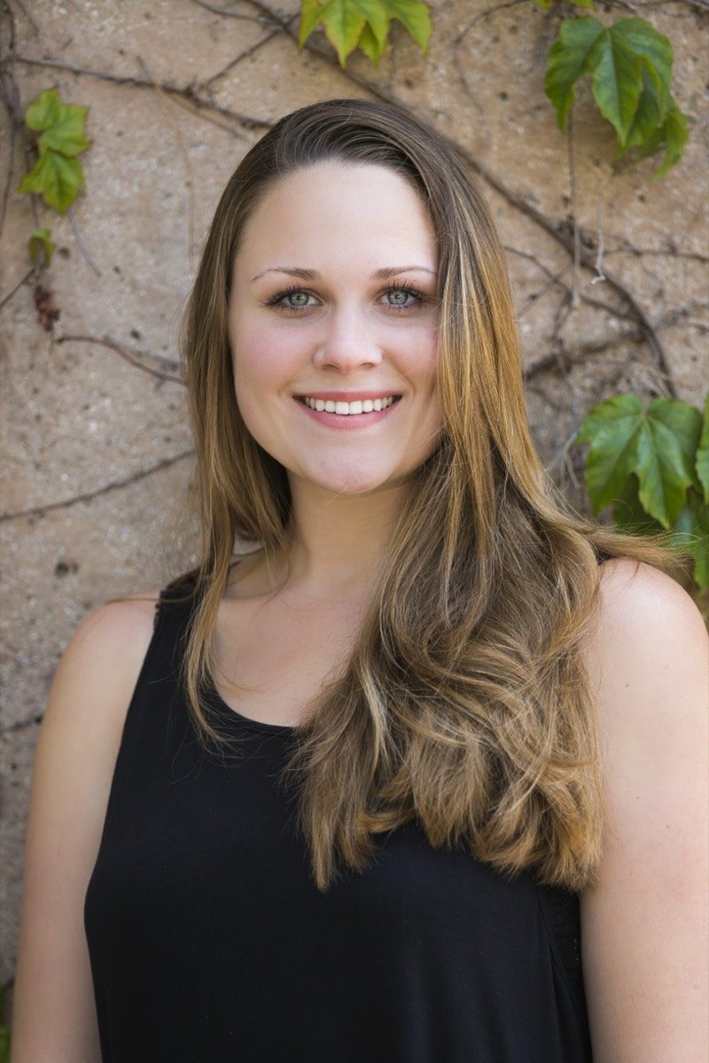 Outdoor portrait of a woman with long hair against a stone wall