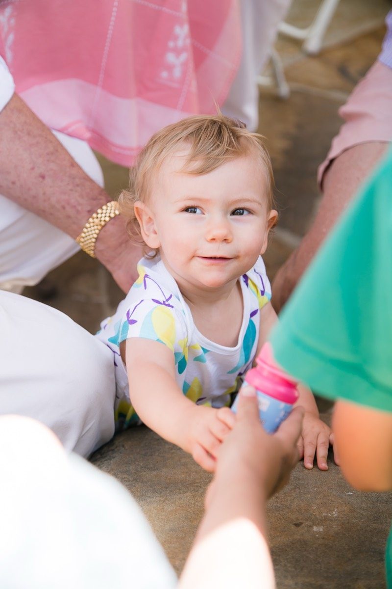 Baby in a pink dress looking up at the camera