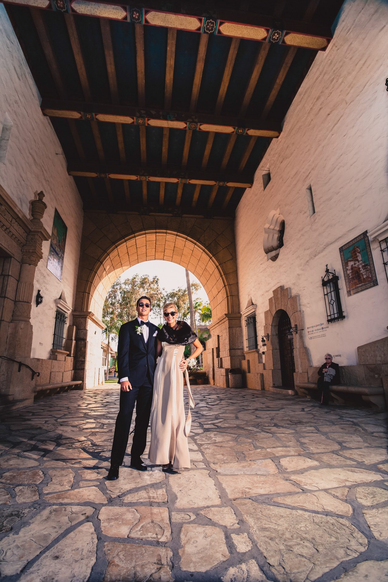 Couple in formal wear beneath the arches of a mission-style courtyard
