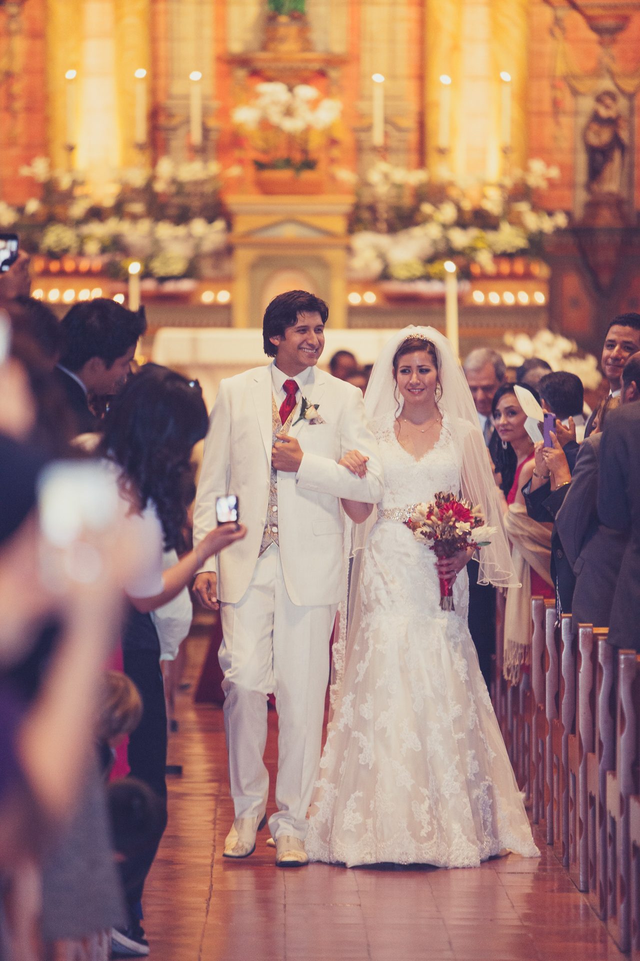 Bride and groom walking up the church aisle after their ceremony