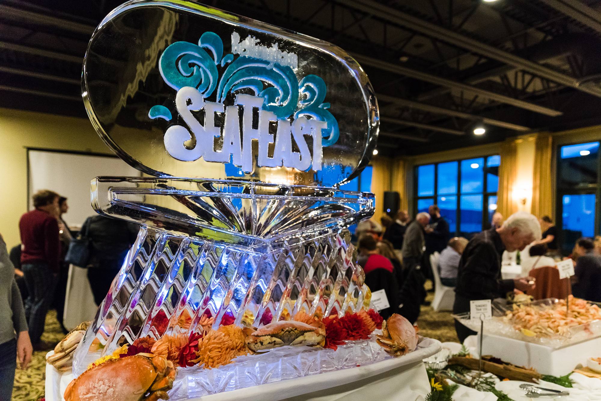 Carved ice sculpture centerpiece on a seafood buffet at an evening reception