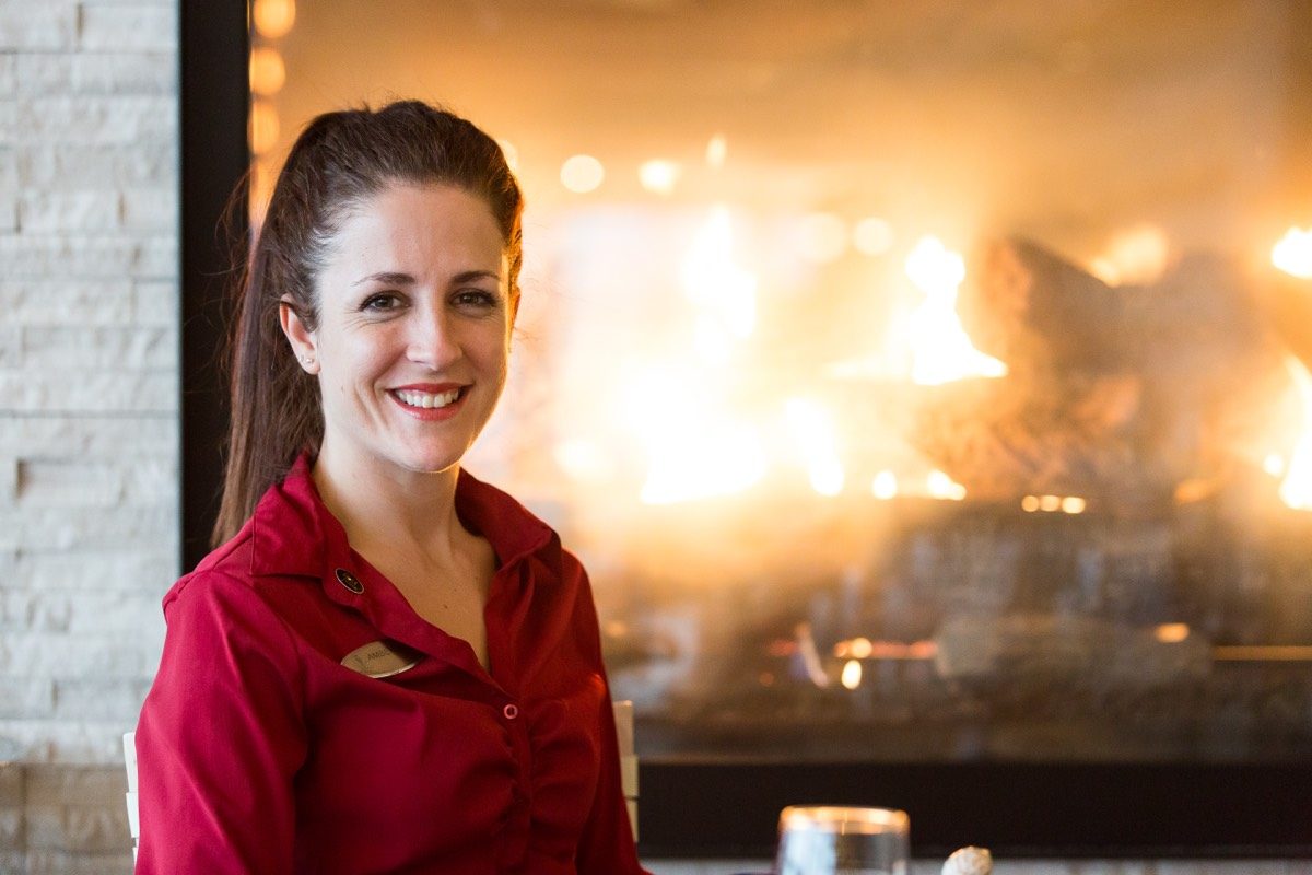 Restaurant owner standing in front of a wood-fired oven