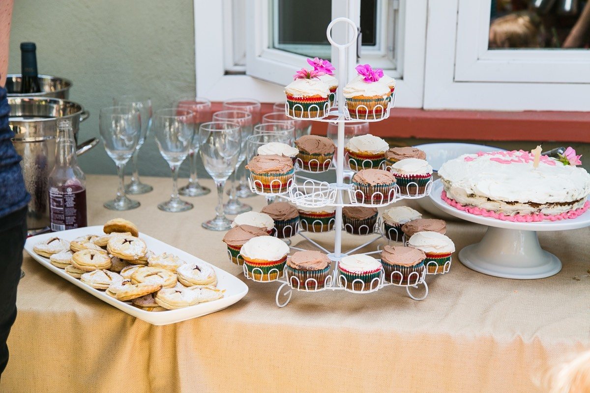 Dessert table with a cupcake tower, cookies, a frosted cake and champagne flutes